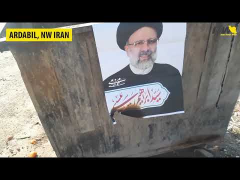 Iranians tearing down and burning election posters