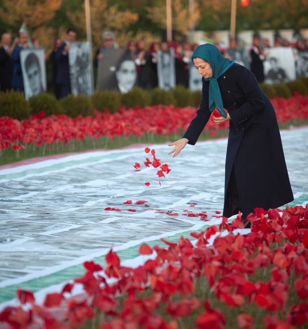 Maryam Rajavi putting flowers on photographs of martyrs of the 2019 protests in Iran - November 10, 2019