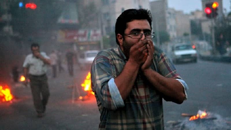 iran-protests-man-protecting-face