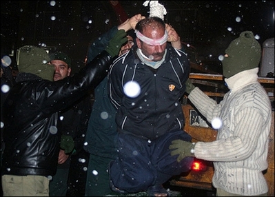 Masked Iranian regime's judiciary officials place the noose around the neck of a man prior to his public hanging in the central city of Qom, Jan 2, 2008