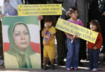 Picture from Reuters - Children stand in front of protestors holding placards and a picture of Maryam Rajavi, leader of the Iranian resistance, Peoples Mojahedin Organization, during a demonstration in front of the United Nations headquarters in Geneva August 20, 2008. Placards read "Consequences of the withdrawal of Ashraf's camp Protection : Humanitarian disaster" and "No to transfer of Ashraf's Protection" 