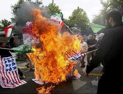 Iranian protestors burn representations of flags of some western countries  during a demonstration in front of the British Embassy to protest what they call "western countries meddling in Iran's domestic affairs," in Tehran, Tuesday, June 23, 2009