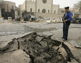 A policeman stands guard at the scene of a bomb explosion outside a Chaldean church in Baghdad, Iraq. 