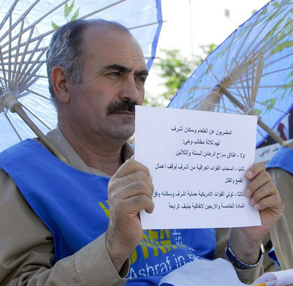 A man from Camp Ashraf holds a sign that states their demands as they go on a hunger strike during a protest against Iraqi forces in Camp Ashraf, north of Baghdad August 24, 2009. They will be on the hunger strike until the Iraqi government agree to their demands, which are, releasing 36 prisoners captured by Iraqi forces, the withdrawal of Iraqi forces and the addition of U.S. forces to the camp.
