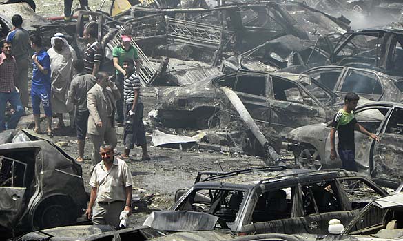 Residents gather at the site of a truck bomb attack outside the Iraqi Ministry of Foreign Affairs in Baghdad, August 19, 2009
