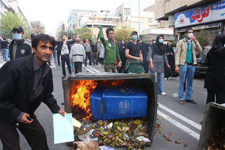 An anti-government protestors attending a protest, as a garbage can is set on fire,  in Tehran, Iran, Wednesday, Nov. 4, 2009.