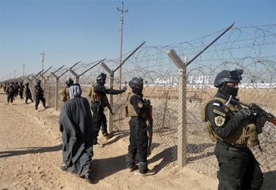 Iraqi forces stand guard outside Camp Ashraf, home to exiled Iranian opposition members. (Dec. 9, 2011)