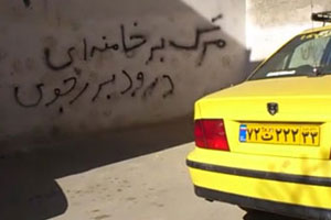 A anti-regime graffiti reads: 'Down with Khamenei, Viva Rajavi' in a street in Tehran.