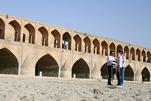 Iranians standing in dried river bed of Zayandehrud river in Isfahan