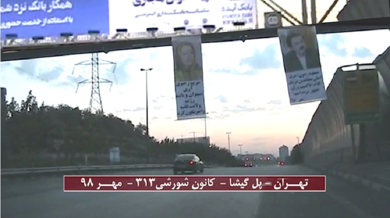 Banners of the Iranian opposition leaders (Massoud Rajavi and Maryam Rajavi) hung from a pass-over in one of Tehran's main motorways